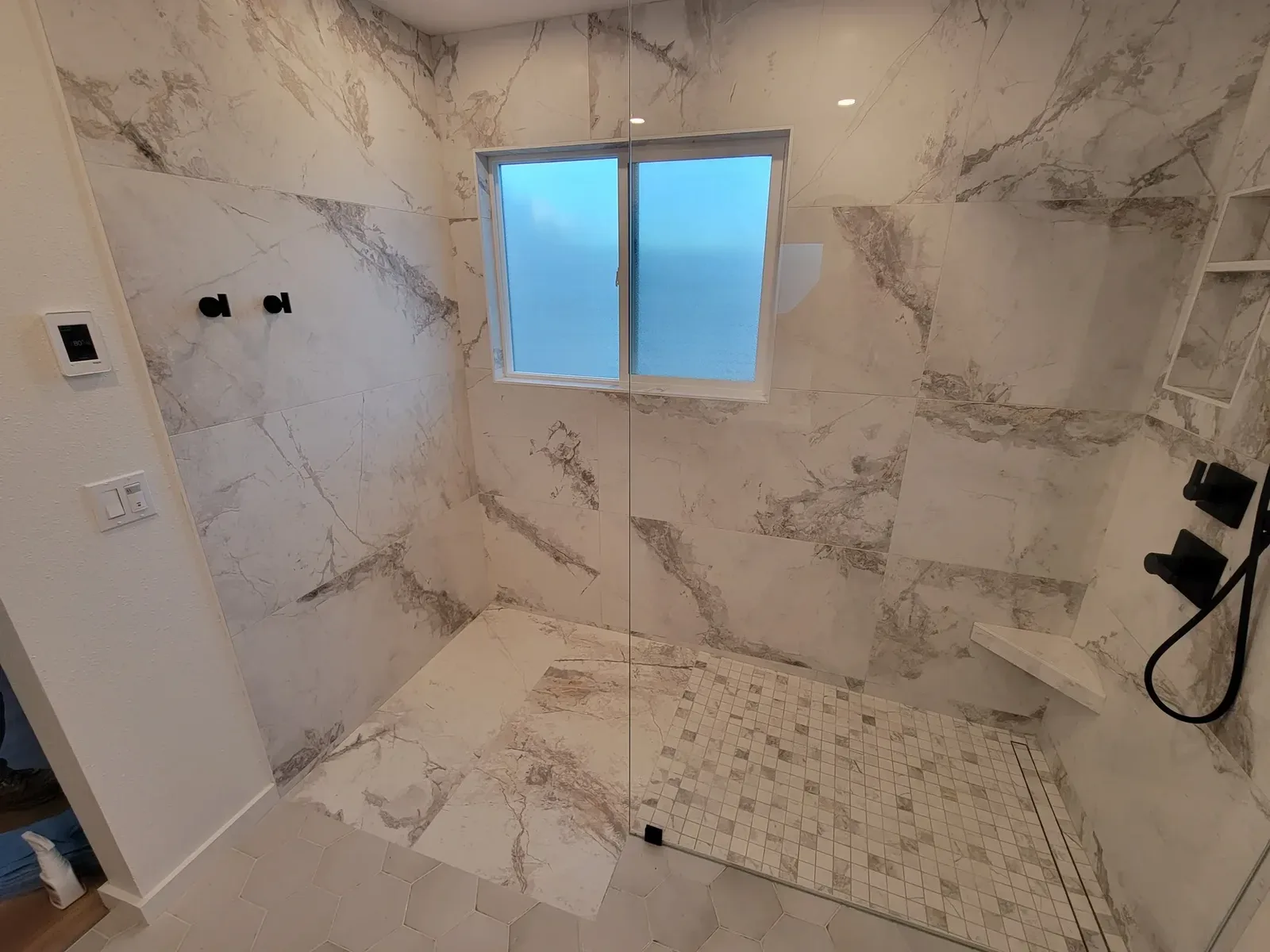 bathroom remodel with black accent tile shower