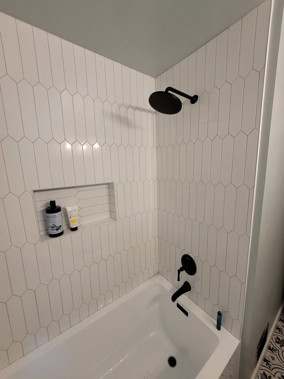 bathroom remodel with black tile shower floor and glass enclosure