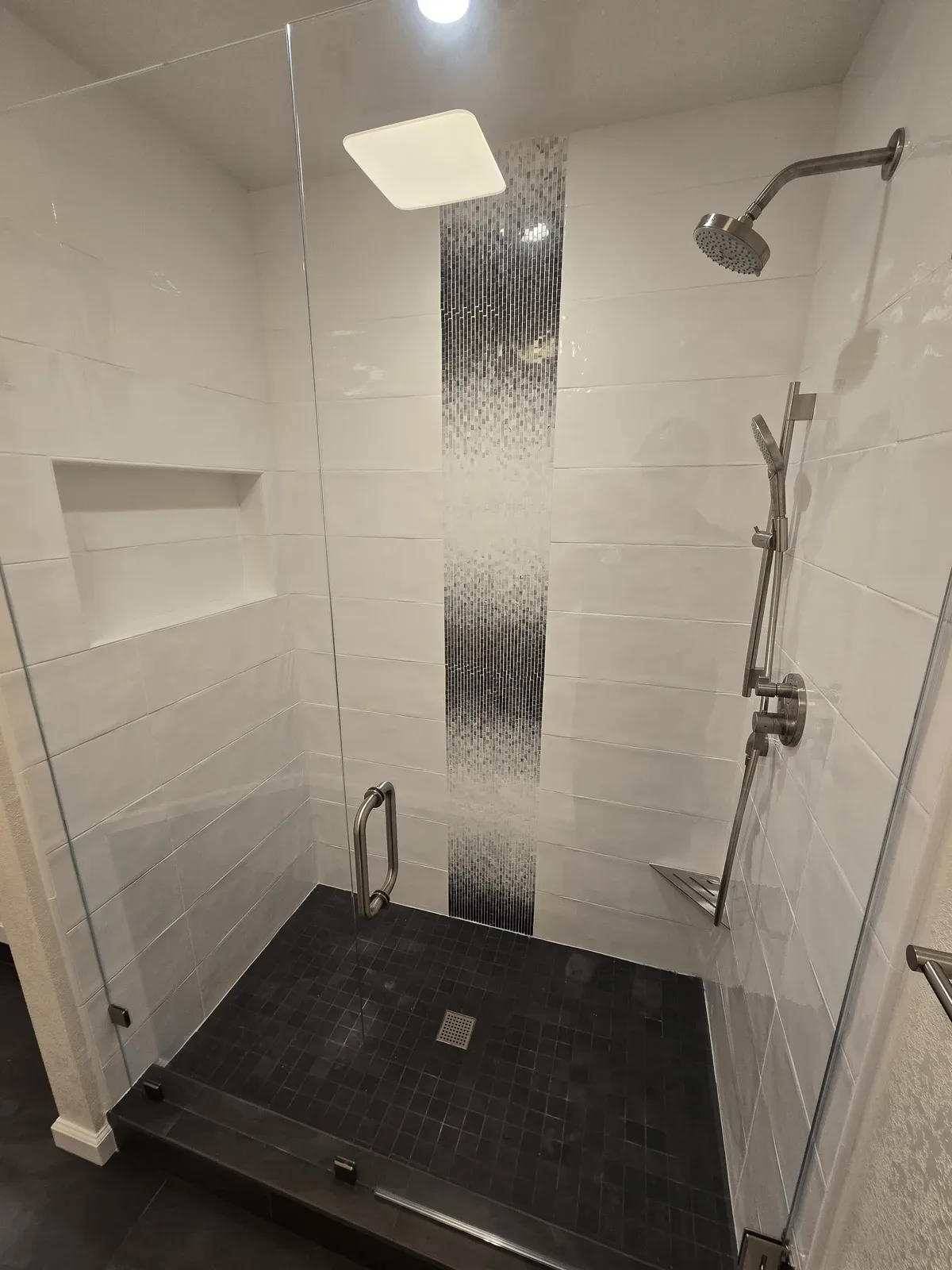 dark tile shower remodel with glass enclosure
