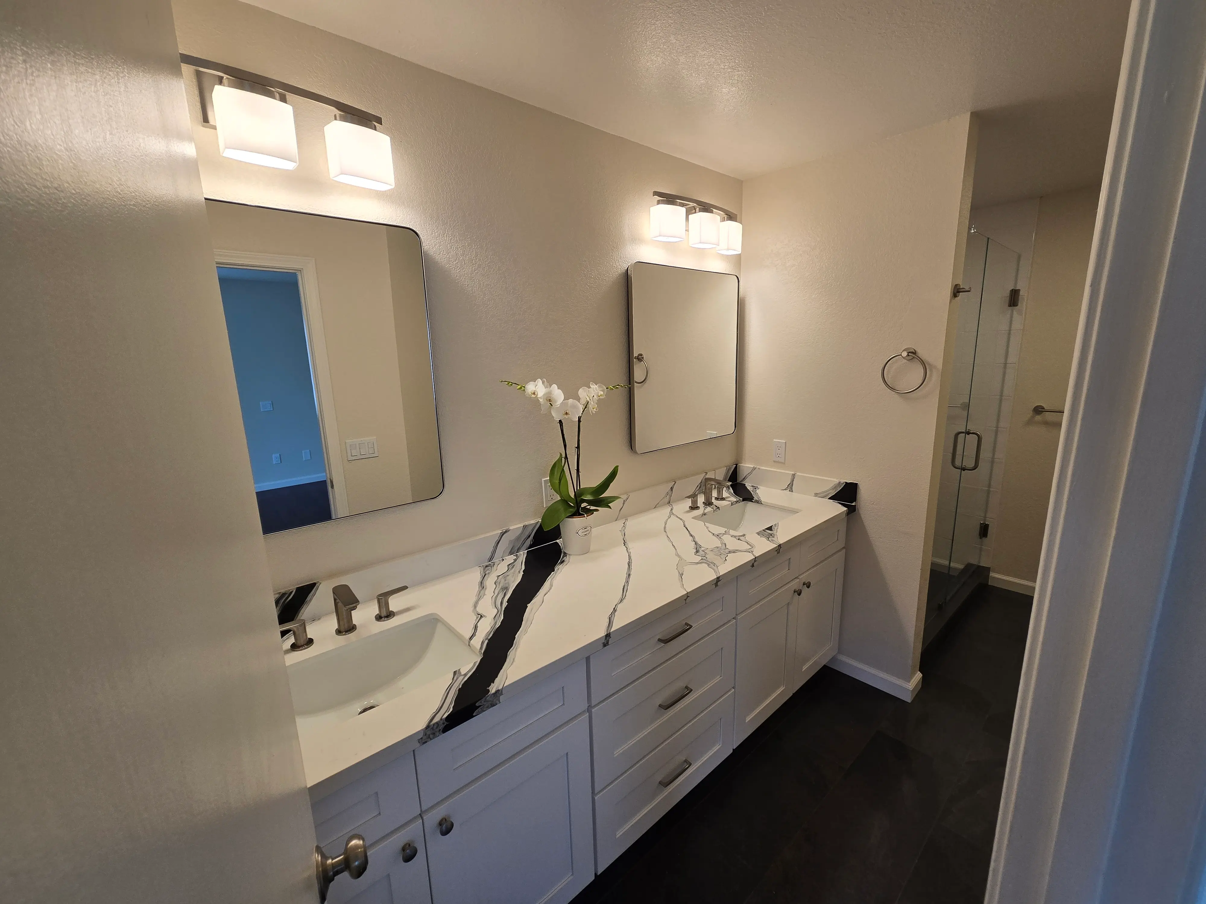 bathroom shower remodel with dark tile accents